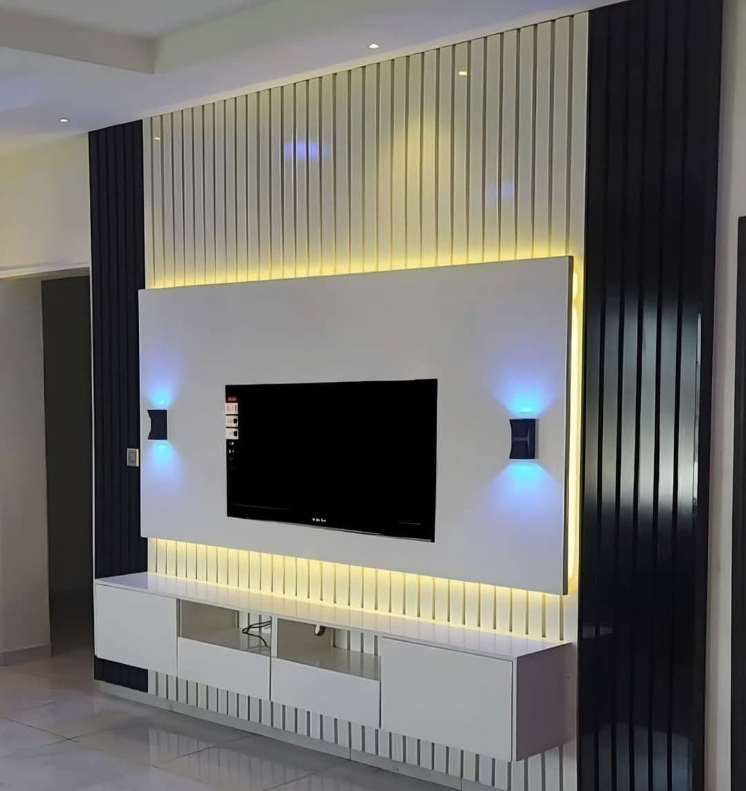 Illuminated black and white slatted TV wall