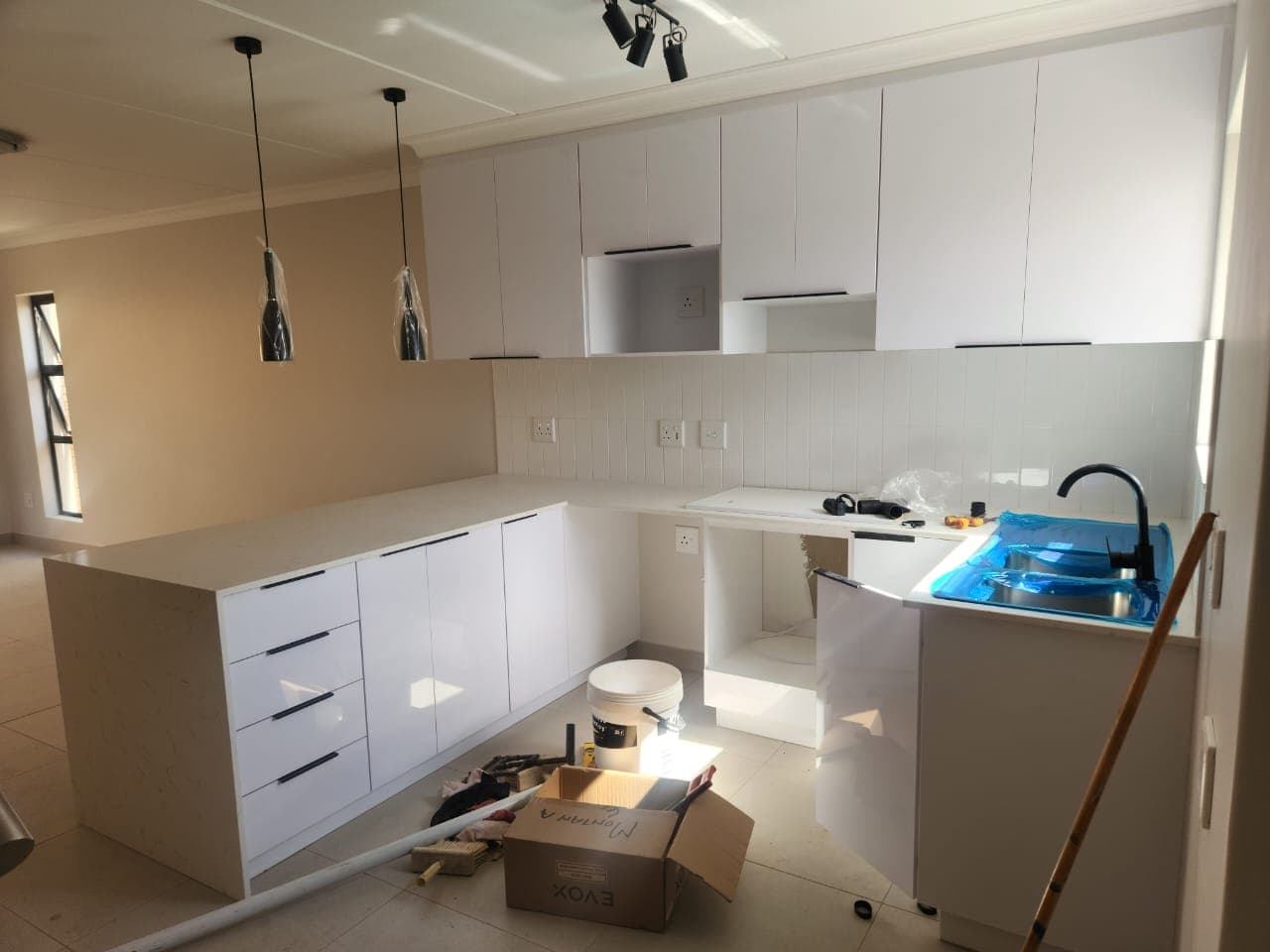 White U-shape kitchen with pendant lighting